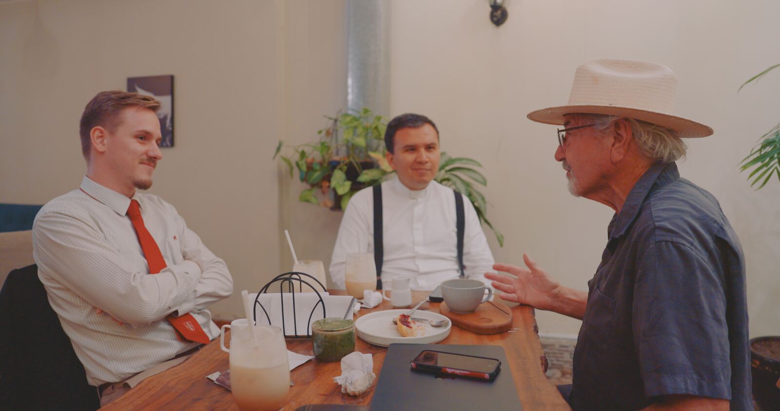 Louis, Father Cesar and Stan Herd talking over coffee